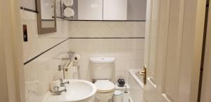 a white bathroom with a toilet and a sink at Delight Marvel - Cades Place in Maidstone +23 photos