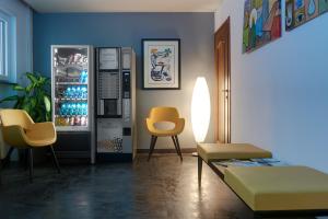 a living room with a refrigerator and two chairs at Hotel Asterix in Bolzano