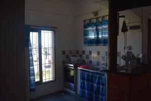 Una cocina con estufa, fregadero y ventana. en APARTAMENTO EN EL CENTRO, en La Paloma
