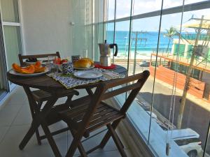 a table with a breakfast on it with a view of the beach at Lar Expresso 2222 in Salvador