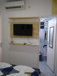 un soggiorno con una TV a schermo piatto su una parete di Flat Porto a Porto De Galinhas