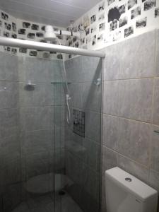e bagno con doccia, servizi igienici e doccia in vetro. di Flat Porto a Porto De Galinhas Altre 25 foto