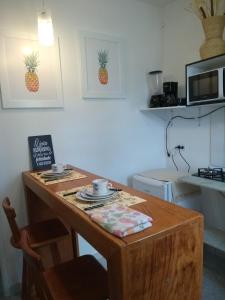una cucina con tavolo in legno con due tazze sopra di Flat Porto a Porto De Galinhas