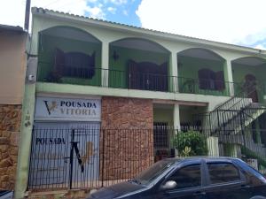 ein Gebäude mit einem davor geparkt in der Unterkunft Pousada Vitória in Aparecida