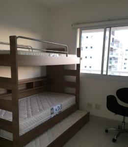 瓜魯雅的住宿－Lazer completo PRAIAS PISCINAS PLAYGROUND，配有两张双层床的客房设有椅子和窗户。