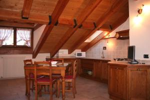 una cocina con armarios de madera y una mesa con sillas. en Maison Chante Lune, en Introd