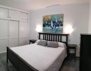 a bedroom with a bed and a painting on the wall at Central Seaview Apartment Puerto del Carmen in Puerto del Carmen