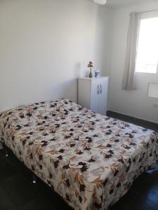 a bed in a room with a flower patterned mattress at Apartamento Bento in Campos dos Goytacazes