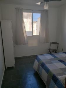 sypialnia z łóżkiem i oknem w obiekcie Apartamento Bento w mieście Campos dos Goytacazes