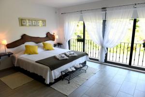 1 dormitorio con 1 cama grande y ventanas grandes en Casa dos Becos, en Riba Douro