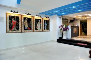 una stanza con quadri su un muro con un vaso di fiori di My Friends Hotel ad Ho Chi Minh