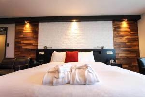 a bedroom with a bed with two towels on it at Hôtel Saint-Germain Rimouski in Rimouski