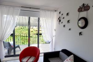 uma sala de estar com uma cadeira vermelha e uma porta de vidro deslizante em Casa dos Becos em Riba Douro
