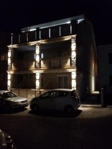 un coche blanco estacionado frente a un edificio con luces en Apartments Vida, en Budva