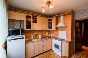 a kitchen with wooden cabinets and a white refrigerator at Квартира на Октябрьской 39 in Salihorsk