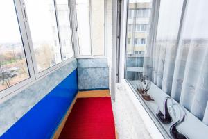 a hallway with a red carpet in a room with windows at Квартира на Октябрьской 39 in Salihorsk