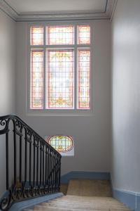 a staircase with stained glass windows in a room at Le Jardin d'Hiver in Châlons-en-Champagne