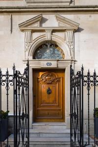 une porte en bois avec une arche au-dessus du bâtiment dans l'établissement Le Jardin d'Hiver, à Châlons-en-Champagne