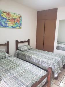 two beds sitting next to each other in a room at Confortável 2 Quartos Castanheiras in Guarapari