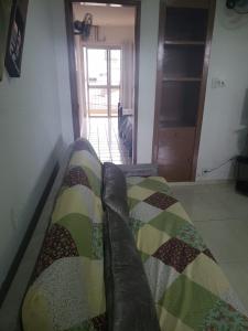 un sofá sentado en una sala de estar con una manta en Confortável 2 Quartos Castanheiras, en Guarapari