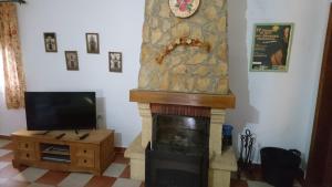 a living room with a fireplace with a clock on the wall at Casa Rural Villa Rosa in Écija