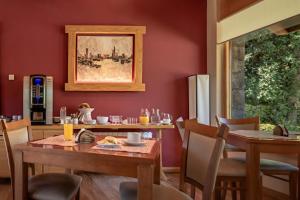 comedor con paredes rojas, mesa y sillas en Antuquelen en Villa La Angostura