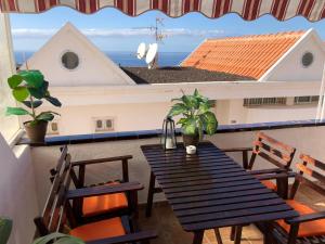 a table and chairs on a balcony with a view of the ocean at COLINA BLANCA TENERIFE. in Adeje