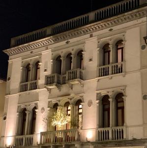 ein weißes Gebäude mit einem Weihnachtsbaum davor in der Unterkunft Palazzina Mori - Luxury B&B in San Donà di Piave