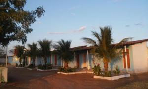 a row of palm trees in front of a building at Pousada Nathymar in Piranhas