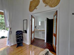 Sails Beach House في لوجنفيل: غرفة معيشة مع كرسي وأرضية خشبية