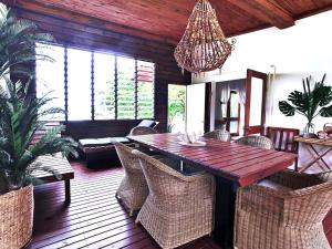 a dining room with a wooden table and chairs at Sails Beach House in Luganville
