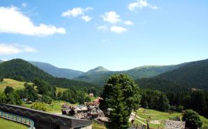 Blick auf ein Dorf in einem Tal mit Bergen in der Unterkunft AAApartmán in Donovaly