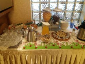 une table avec un tissu de table et de la nourriture dans l'établissement Pensiunea Dapa, à Predeal
