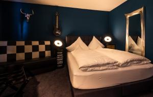 Engel Hotel + Diner في آولندورف: غرفة نوم مع سرير ومرآة على الحائط