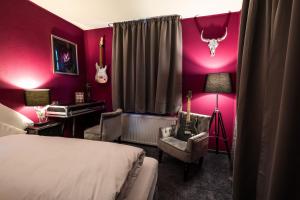 a bedroom with a bed and a room with pink walls at Engel Hotel + Diner in Aulendorf