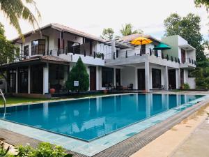 a house with a swimming pool in front of it at Siluni's Villa in Anuradhapura