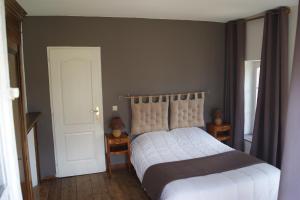 1 dormitorio con cama blanca y puerta blanca en Gîtes Normands de charme les châtaigniers, en Bretteville-du-Grand Caux