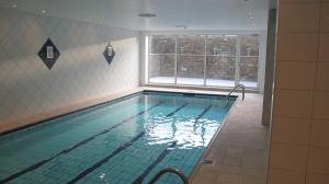 a large swimming pool in a room with a window at Geilo Superior leilighet in Geilo