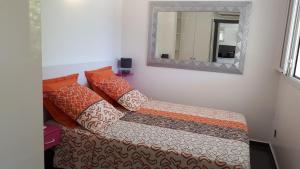 un sofá con almohadas y un espejo en una habitación en JoliReveCreole, en Sainte-Anne 9 fotos más