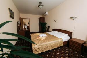 スモレンスクにあるHotel Prahaのベッドと植物のあるホテルルーム