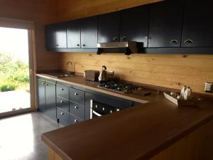 a kitchen with black cabinets and a counter top at Casa La Trafa in Futrono