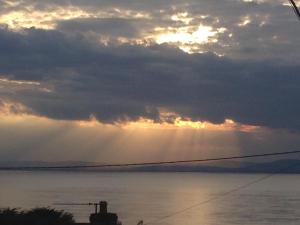 a view of the sun shining through the clouds over the water at The Nook @ Drop Anchor in Portishead
