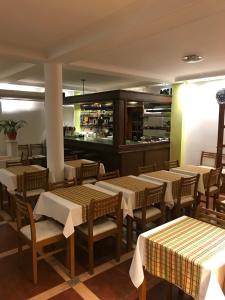 Un restaurante con mesas y sillas y una cocina. en Onais Hotel, en Mar de Ajó