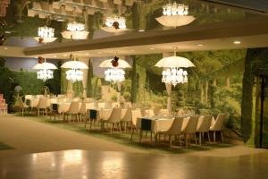 a banquet hall with tables and chairs and chandeliers at RAYA Garden - Park Hotel & Winery in Veliko Tŭrnovo