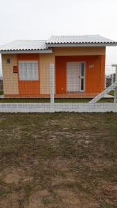 a small house with an orange and white at Casa Praia de Arroio do Sal - Balneário São Paulo in Arroio do Sal