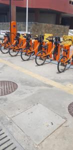 a row of orange bikes parked in a parking lot at Farol Barra flat 412 in Salvador