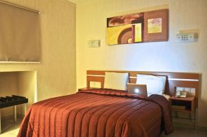 1 dormitorio con 1 cama con ordenador portátil en Hotel Interforum, en León