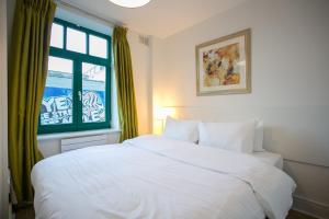 ein Schlafzimmer mit einem weißen Bett und einem Fenster in der Unterkunft Temple Bar District Apartments in Dublin