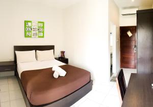 a bedroom with a bed with a towel on it at Naturela in Uluwatu