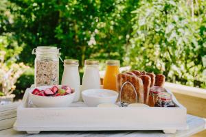 a tray of food with bread and bottles of milk at Studio on Petley in Tairua